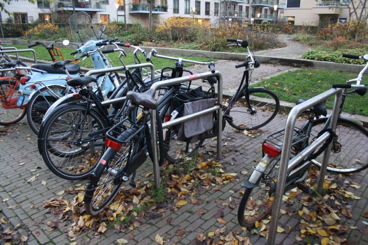 Geparkeerde fietsen nemen een groot deel van de stoep in beslag.